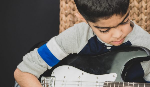 A boy practicing his guitar at home. Music is increasingly taught as a subject in schools in the UK.